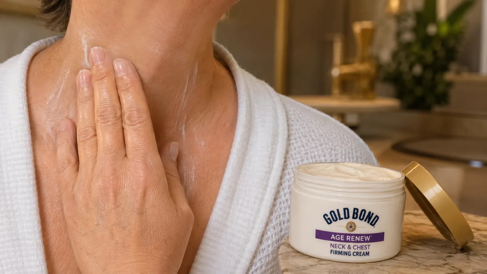 Close up of a hand applying Gold Bond Age Renew Neck & Chest Firming Cream to the neck in upward strokes